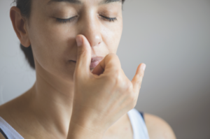 An individual engaging in alternate nostril breathing, a technique used to balance the nervous system.