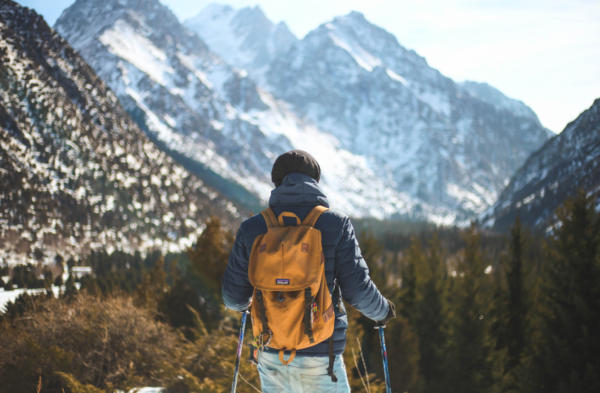 Person standing on a mountaintop, symbolizing personal growth and challenging fear.