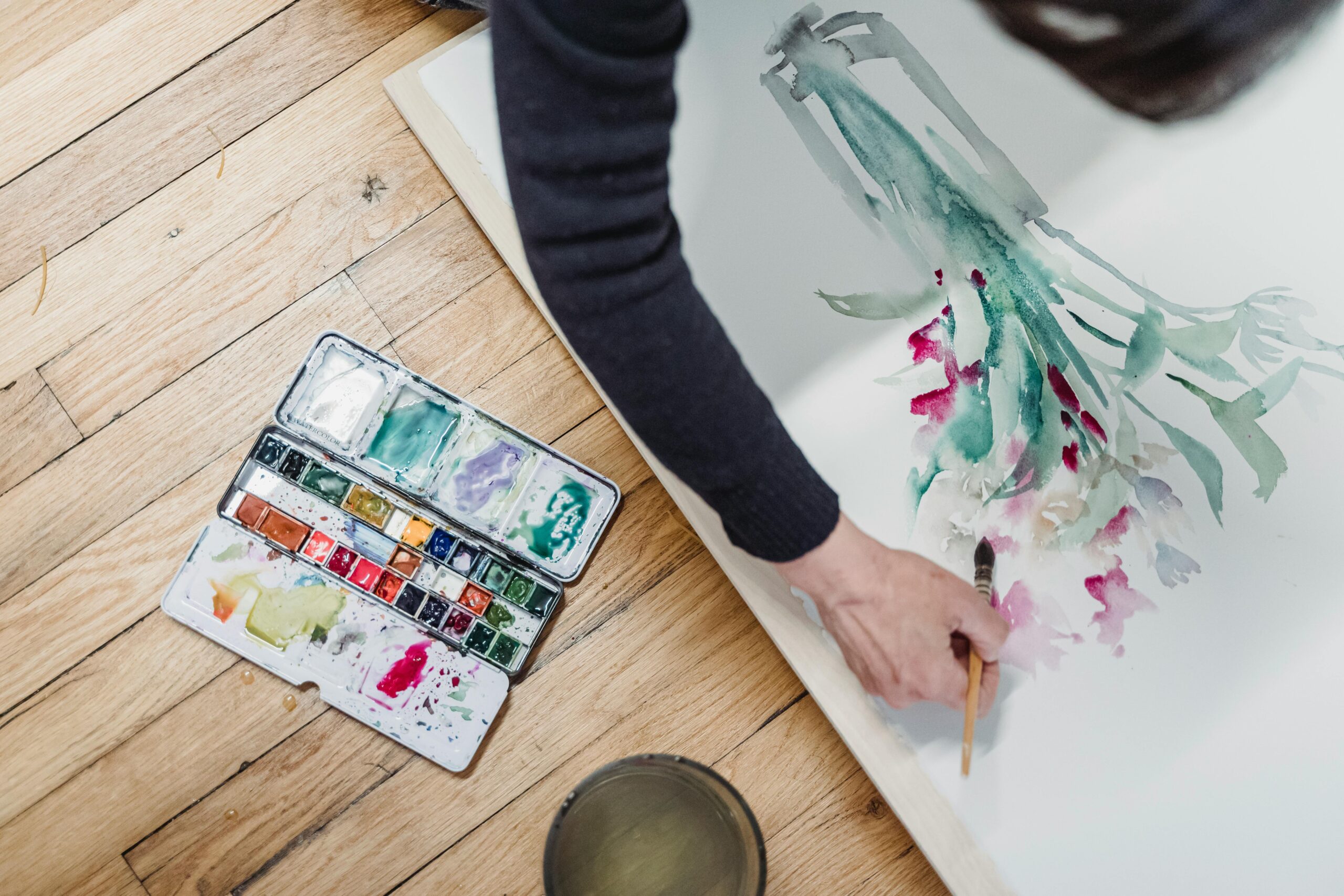 Person expressing creativity through vibrant watercolor painting